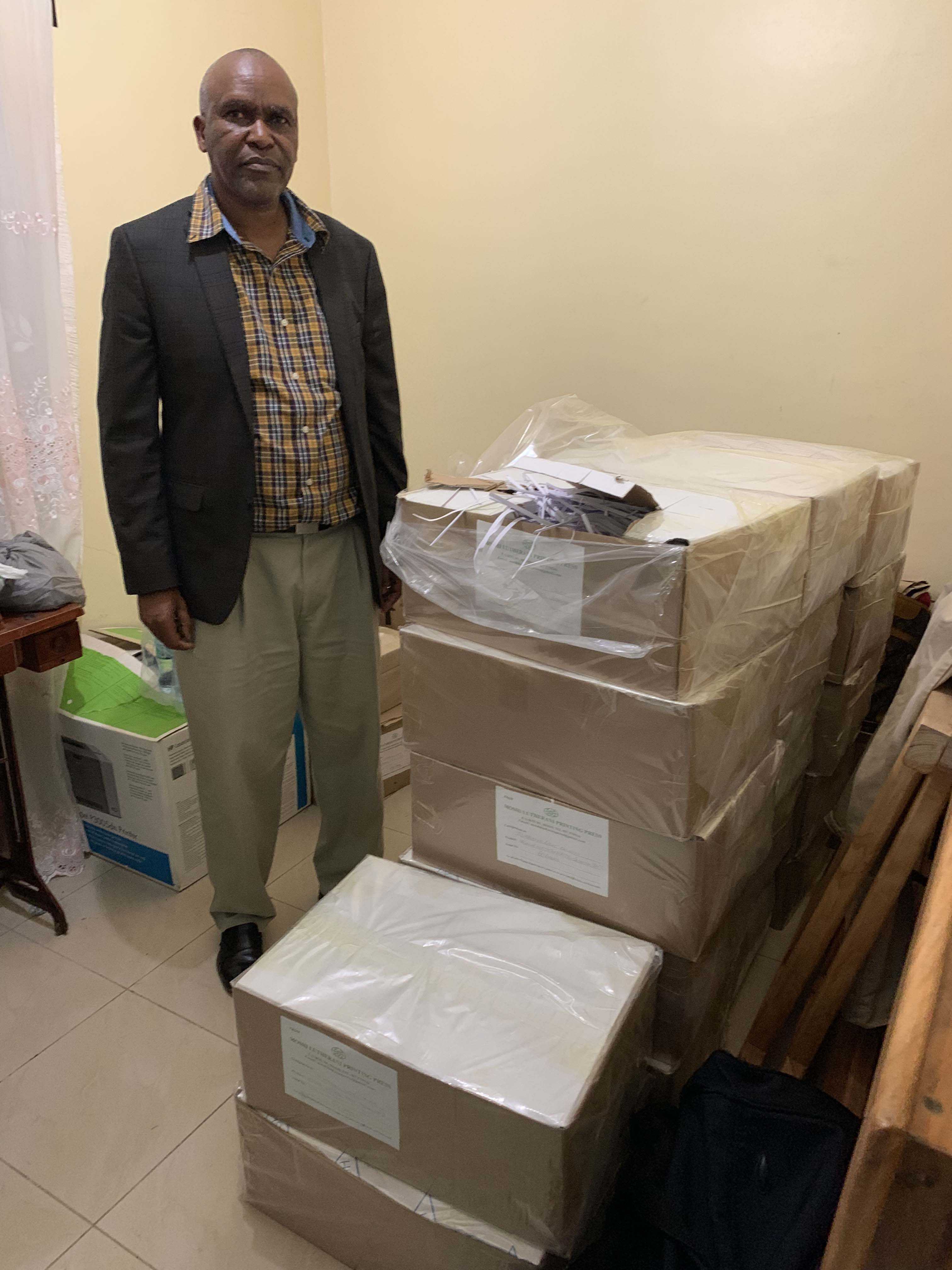 Bro. Elias stands beside 1,000 Swahili books that have been printed inside the country in Moshe.