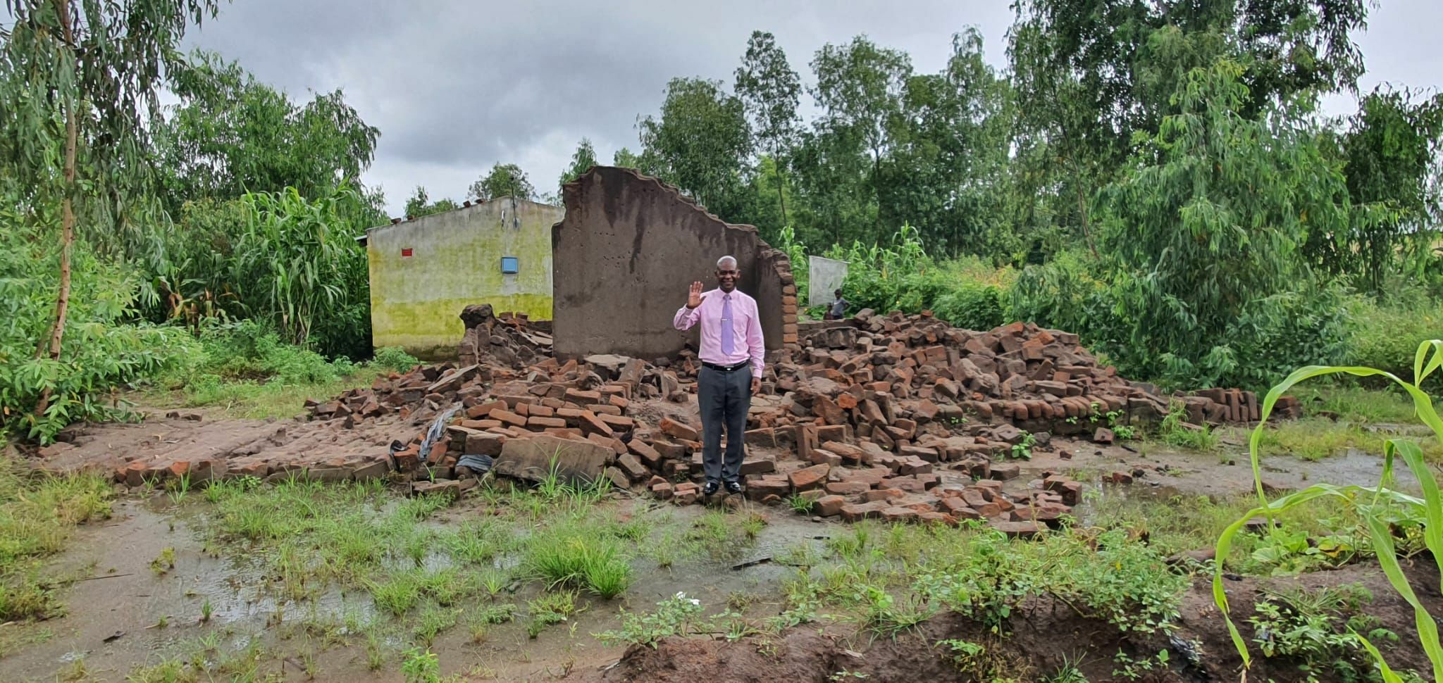 Pastor in front of what used to be his home in Malawi